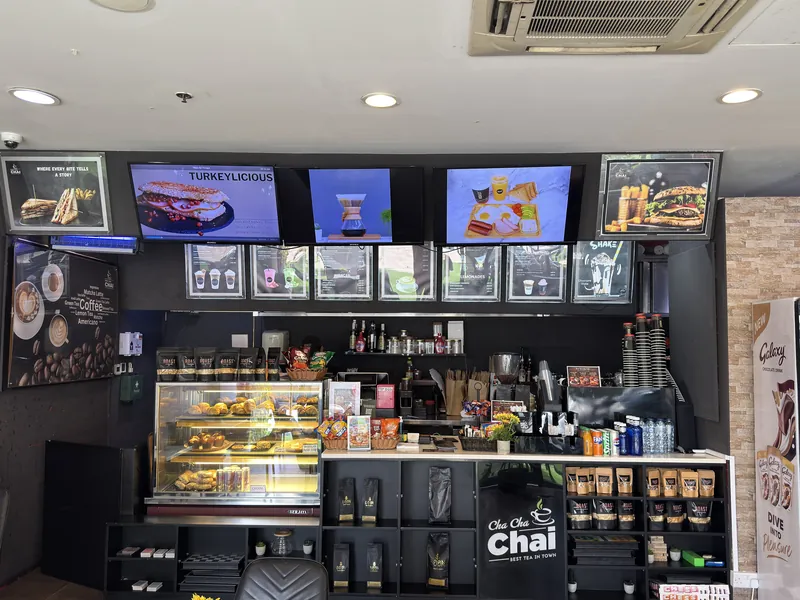 The counter at ROAST Dubai Silicon Oasis with bakery display and menu screens